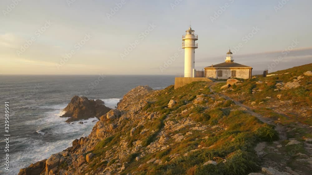 Sea landscape view of Cape Tourinan Lighthouse at sunset with pink clouds, in Spain Sea landscape view of Cape Tourinan Lighthouse at sunset with pink clouds, in Spain