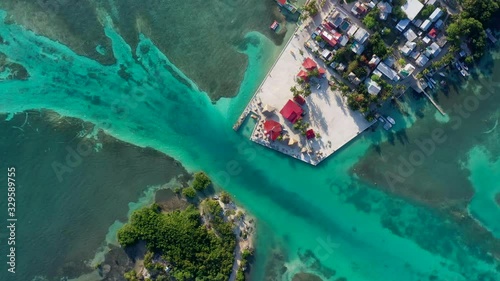 Aerial, screwdriver, drone shot top down above the split lagoon, and the Caye Caulker island, on a sunny day, in Belize, Central America