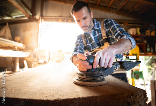 Carpenter using woodworking tools for craft work in carpentry workshop