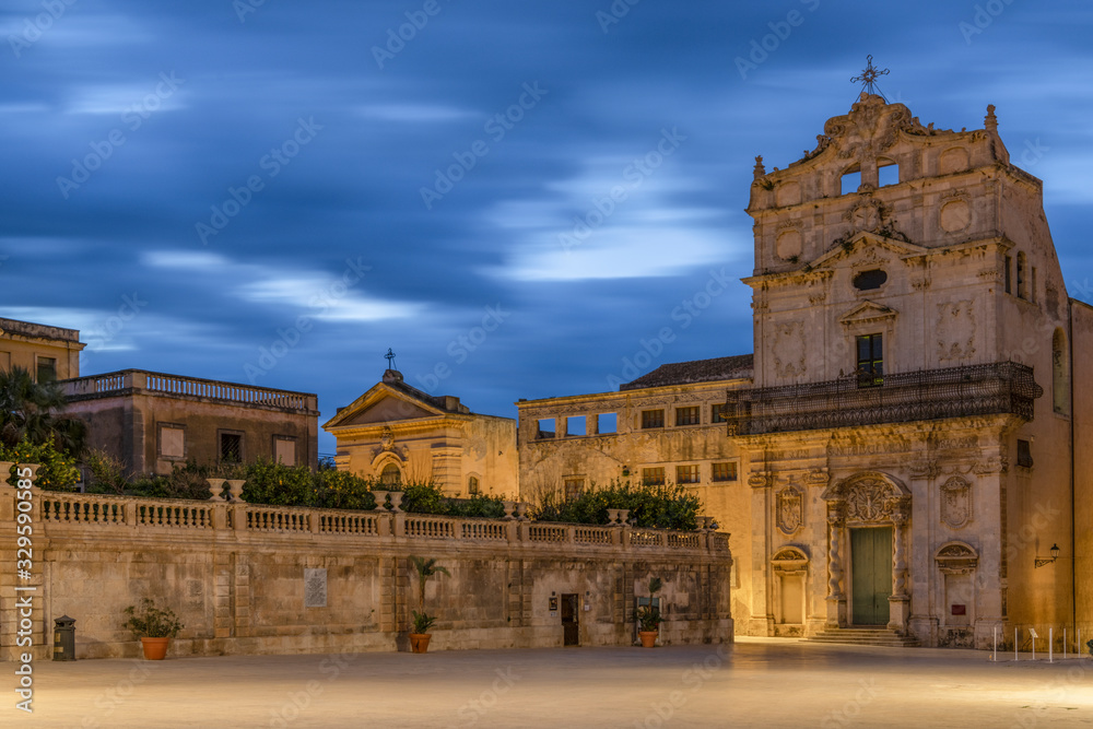 Main historic city center of Ortygia island and view of the church Santa Lucia alla Badia in Sicily at sunrise with amazing blue sky