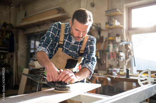Carpenter using woodworking tools for craft work in carpentry workshop