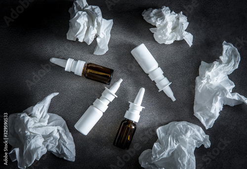 Nasal spray dipendence concept. When using DNSs for too long it causes rather than prevents congestion, rhinitis medicamentosa. Lot of empty used nasal spray dispenser bottles scattered on table. photo