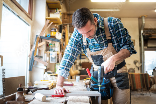 Carpenter using woodworking tools for craft work in carpentry workshop