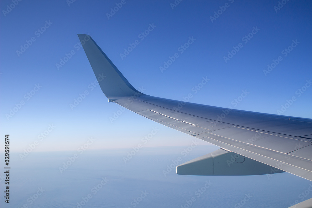 Fototapeta premium Airplane wing in the sky. View from a great height.