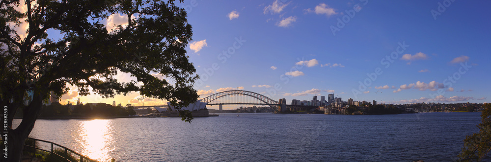 Panorama of Sydney Harbour bridge on a warm summer afternoon at Sunset blue skies and white orange clouds