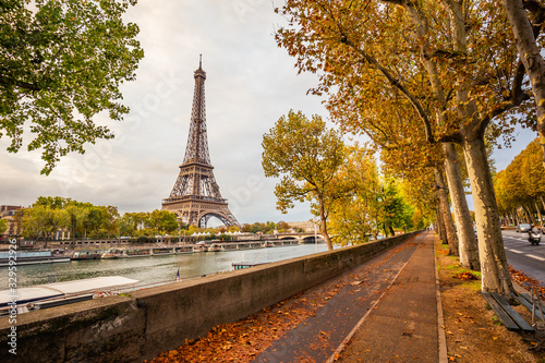 Deserted bike path with the Eiffel tower and the banks of the Seine river in Paris France on an autumn day surrounded by brown leaves of trees