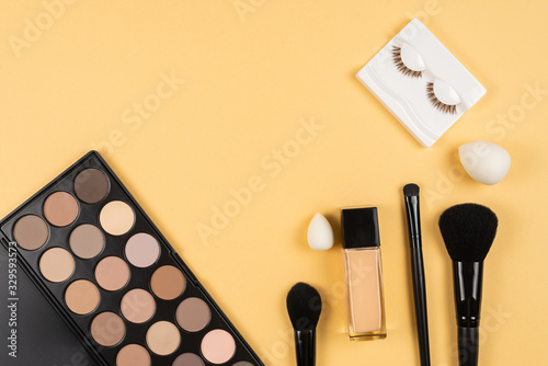 Professional makeup products with cosmetic beauty products, eye shadows, eye lashes, beauty blender, foundation.