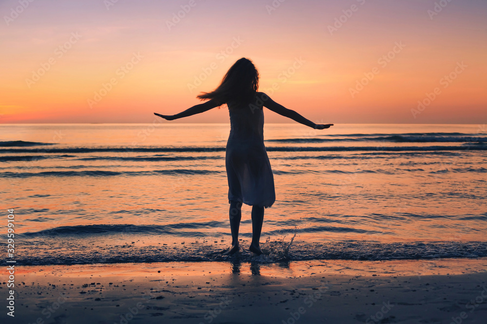 enjoy life in summer, silhouette of happy beautiful woman dancing on sunset beach, happiness