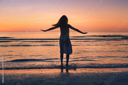 enjoy life in summer, silhouette of happy beautiful woman dancing on sunset beach, happiness