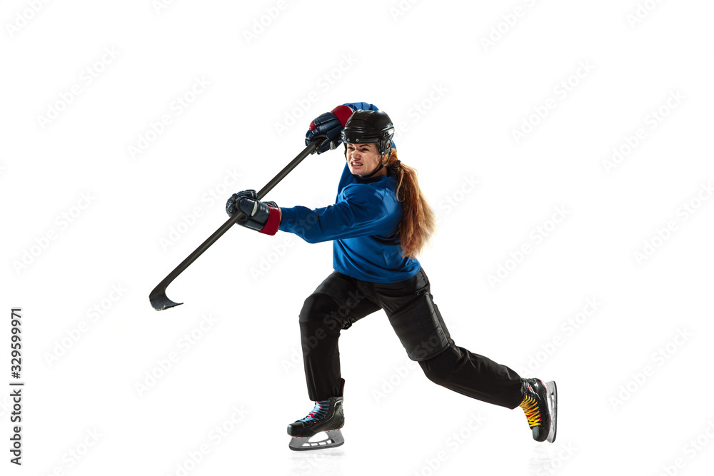Young female hockey player with the stick on ice court and white background. Sportswoman wearing equipment and helmet training. Concept of sport, healthy lifestyle, motion, action, human emotions. Young female hockey player with the stick on ice court and white background. Sportswoman wearing equipment and helmet training. Concept of sport, healthy lifestyle, motion, action, human emotions.