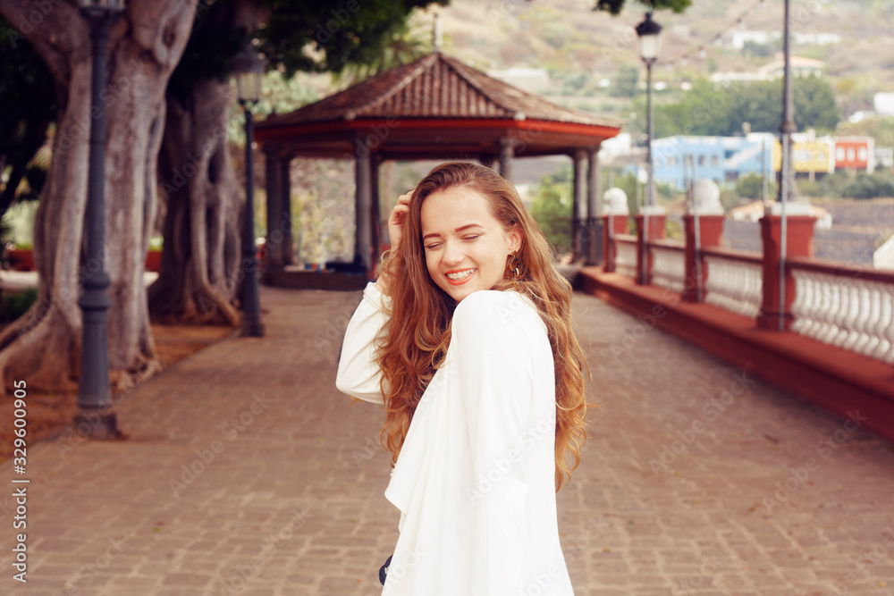 A girl in a white cape walks along the Icod de los Vinos. A girl in a white dress walks. Summer, sport, hiking, walk, Canary. Icod de los Vinos Spain A girl in a white cape walks along the Icod de los Vinos. A girl in a white dress walks. Summer, sport, hiking, walk, Canary. Icod de los Vinos Spain