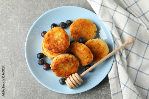 Breakfast of cheese pancakes on grey background, top view