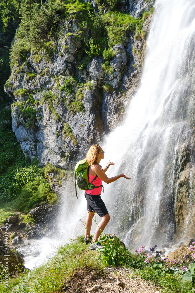 Woman hiker touching water drops at Dalfazer waterfall, Austria. Woman hiker touching water drops at Dalfazer waterfall, Austria.