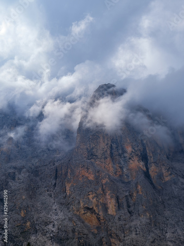 Close up of Sassolungo mountain peak engulfed in stormy clouds, in Dolomites mountains, Italy.