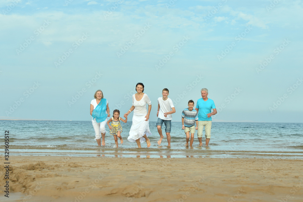 Portrait of happy family together on sand beach