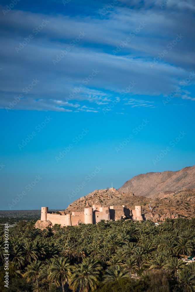 Sunset view of the Nakhal Fort surrounded by a palm grove, Oman