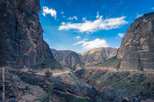 View of the dirt road between mountains on a cloudy day in Jebel Shams, Oman