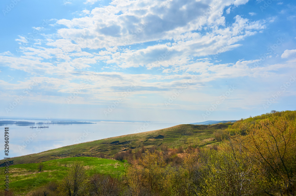 Mountain sea shore in the fall against the blue sky with clouds.