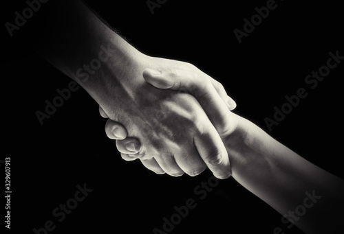 Concept of rescue. Image of the hands of two people during the rescue. Black and white image.