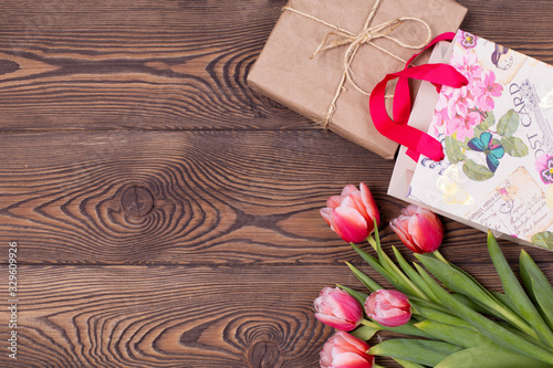 Fototapeta Naklejka Na Ścianę i Meble -  Gift box and tulips flowers on a rustic table on March 8, International Women's Day, birthday or mother's day, beautiful spring card.