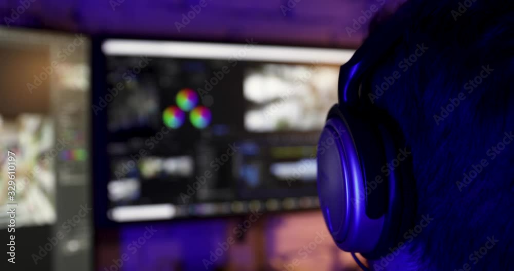 post production - man doing video editing on computer with headphones on