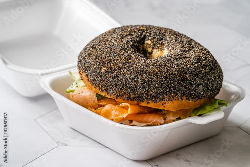 Take Away Salmon Bagel Sandwich with Lox Cream Cheese and Poppy Seeds in Plastic Container Box Package. photo