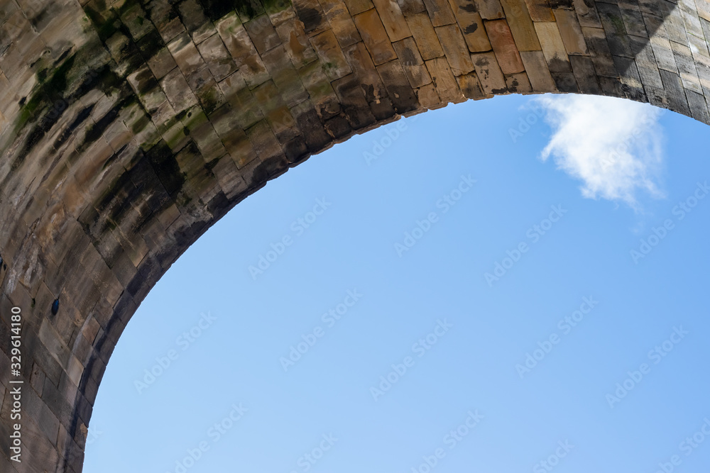One of the High Level Bridge's supporting archways in Newcastle upon Tyne, spanning the River Tyne from Gateshead to Newcastle. Set against a beautiful blue sky.