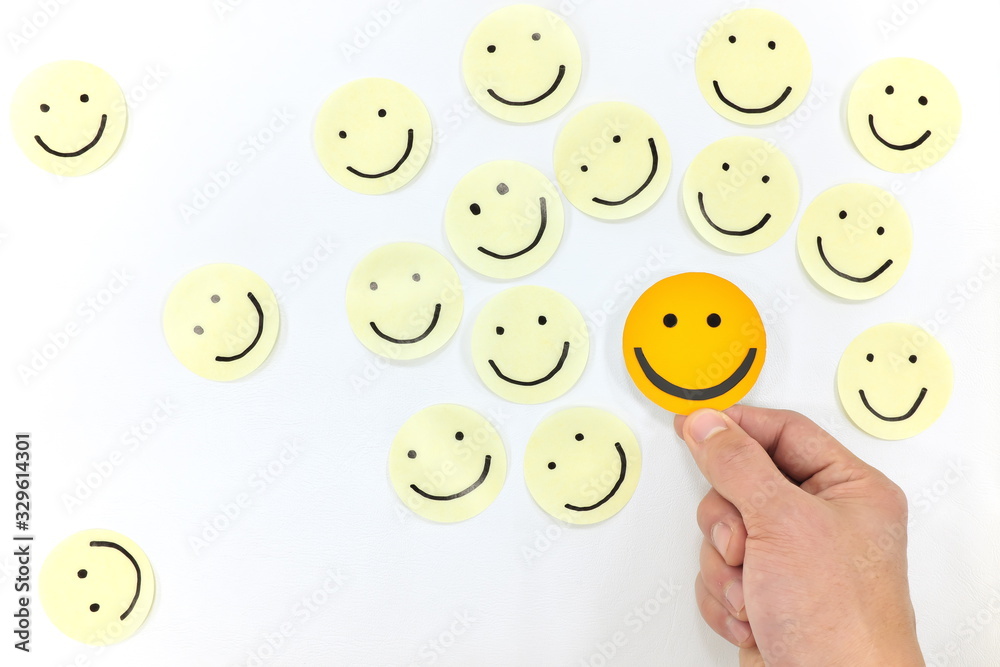 Yellow happy face icons group set top view with human hand. Share happiness positivity and joy concept. Yellow happy face icons group set top view with human hand. Share happiness positivity and joy concept.
