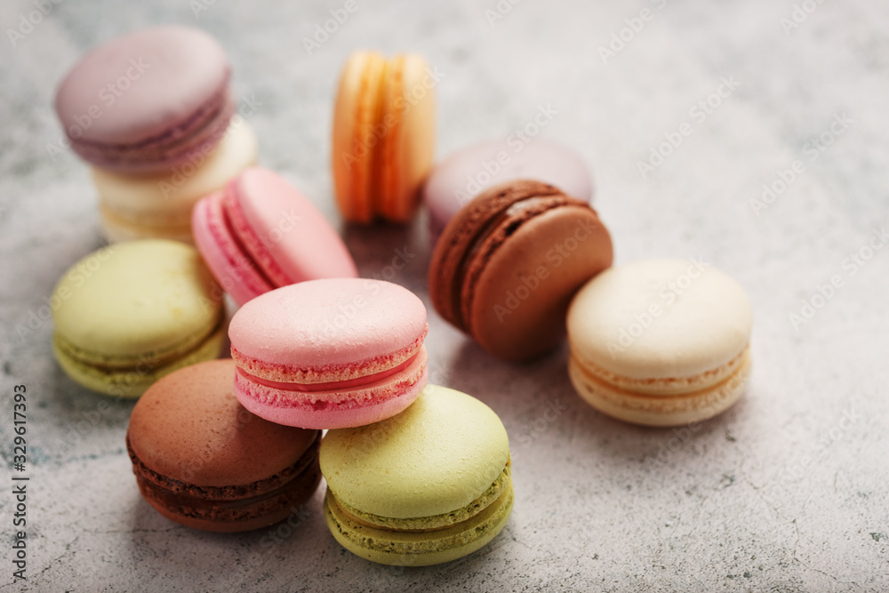 Obraz premium Multicolored macaroni cookies lie on a gray stone slab.