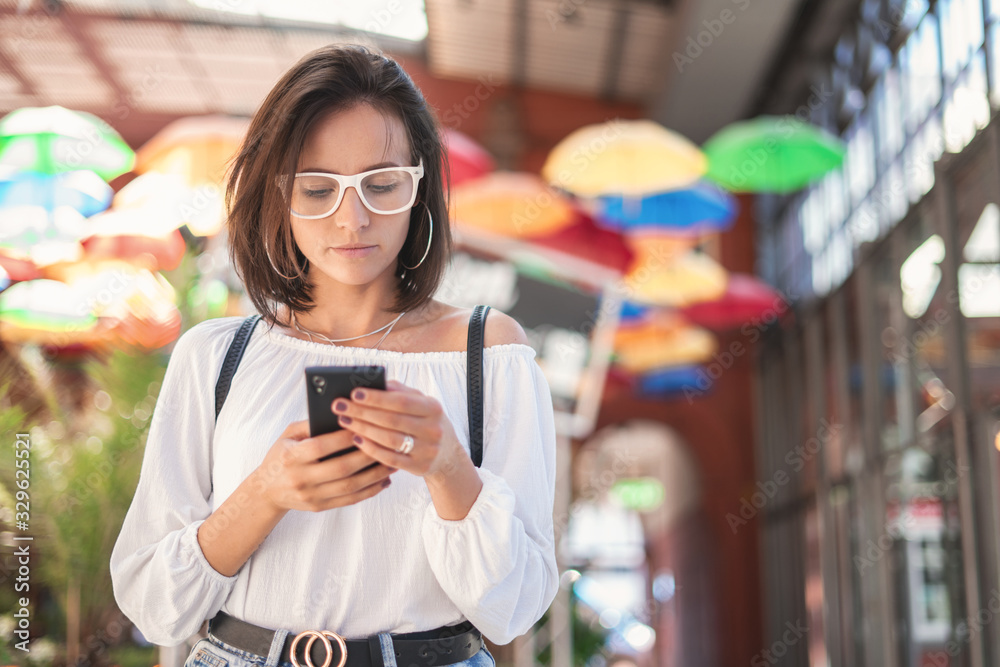 Young woman browsing internet on smartphone standing Young woman browsing internet on smartphone standing
