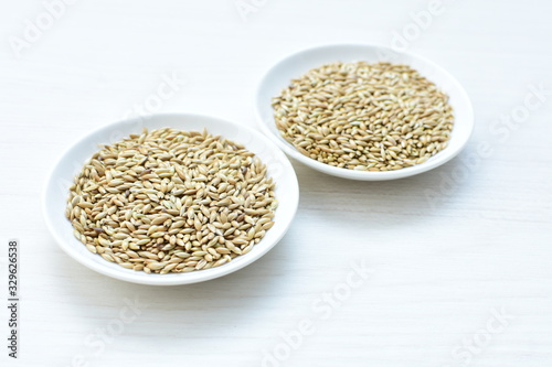 Seed of birdseed, food for birds, displayed in containers on white wooden background