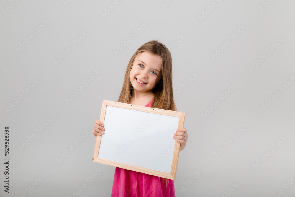 baby girl in diapers holding a drawing Board on a blue background baby girl in diapers holding a drawing Board on a blue background