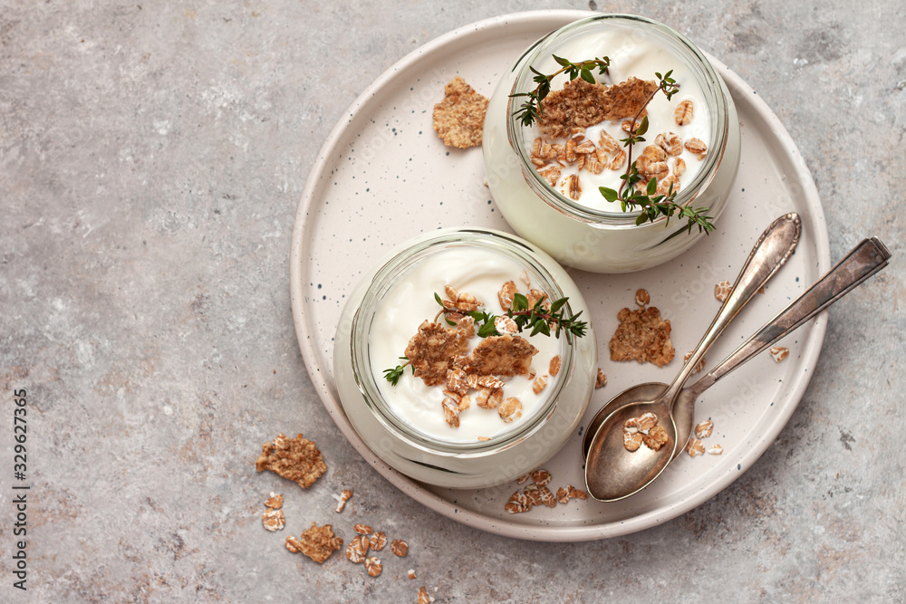 Natural homemade organic yogurt with granola and oatmeal in glass jars Natural homemade organic yogurt with granola and oatmeal in glass jars