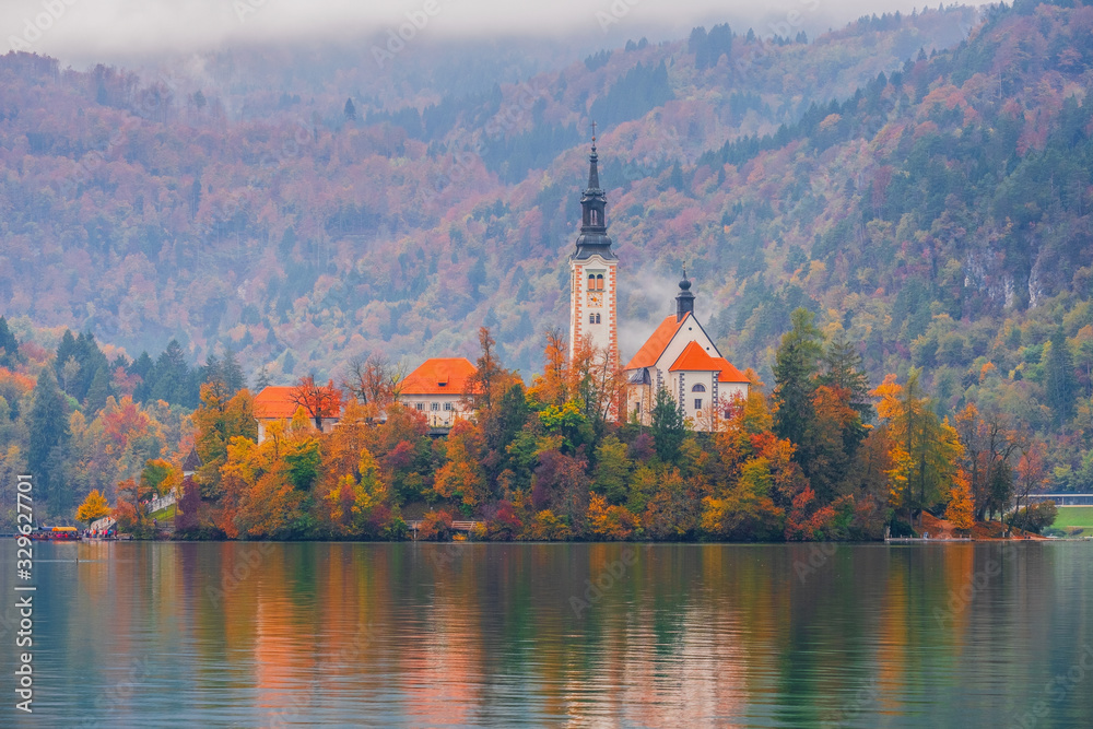 Fototapeta premium Famous Bled Lake in Triglav National Park in the Julian Alps with a forest in autumn colors