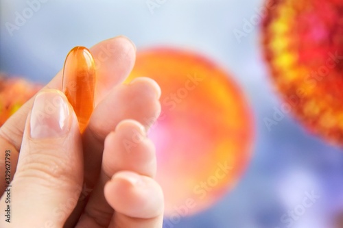 Pills in woman hand on blurred coronavirus bacteria’s on background. Coronavirus disease named COVID-19. Healthcare concept