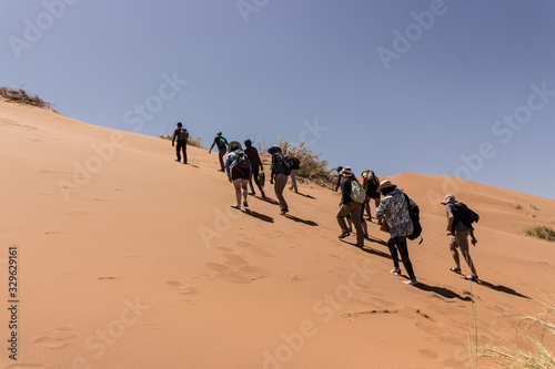 people climbing a desert dune © Arieleon.photogrophy
