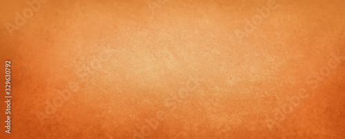 Orange background with old vintage paper texture with dark mottled grunge borders in autumn and halloween colors, old plain solid orange background template