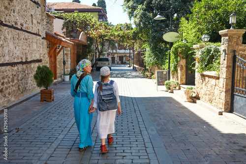 Mom and daughter walking through the streets of Antalya.