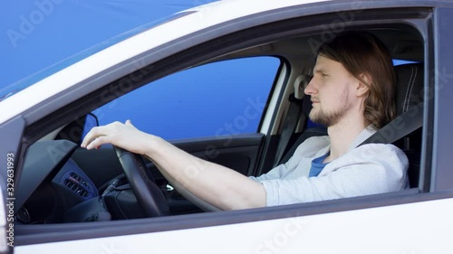 Wallpaper Mural Concentrated on road man is driving in white car against a chroma key background. He looks other cars in left outside and rearview mirrors. Driver is in striped jacket and blue T-shirt. Torontodigital.ca