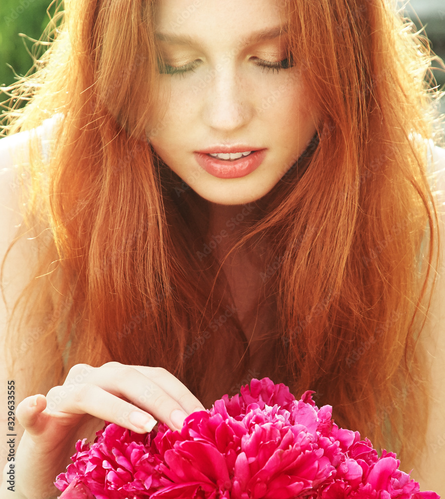 Naklejka premium summer closeup portrait of a young redhead woman with flowers