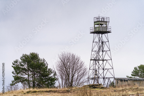 Abandoned military watch tower on small cape on the shore of Finnish Gulf (Baltic Sea, North Europe). Rusted iron framework is partially missing that makes construction dangerous. Beautiful nature.