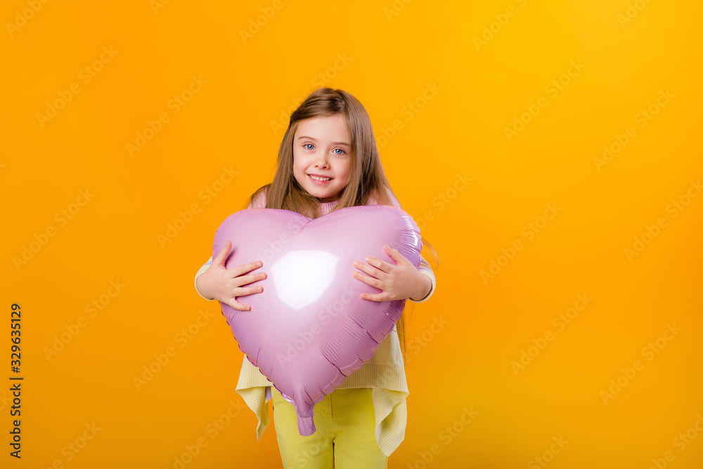 portrait of a happy child girl smiling holding a pink balloon in the shape of a heart portrait of a happy child girl smiling holding a pink balloon in the shape of a heart