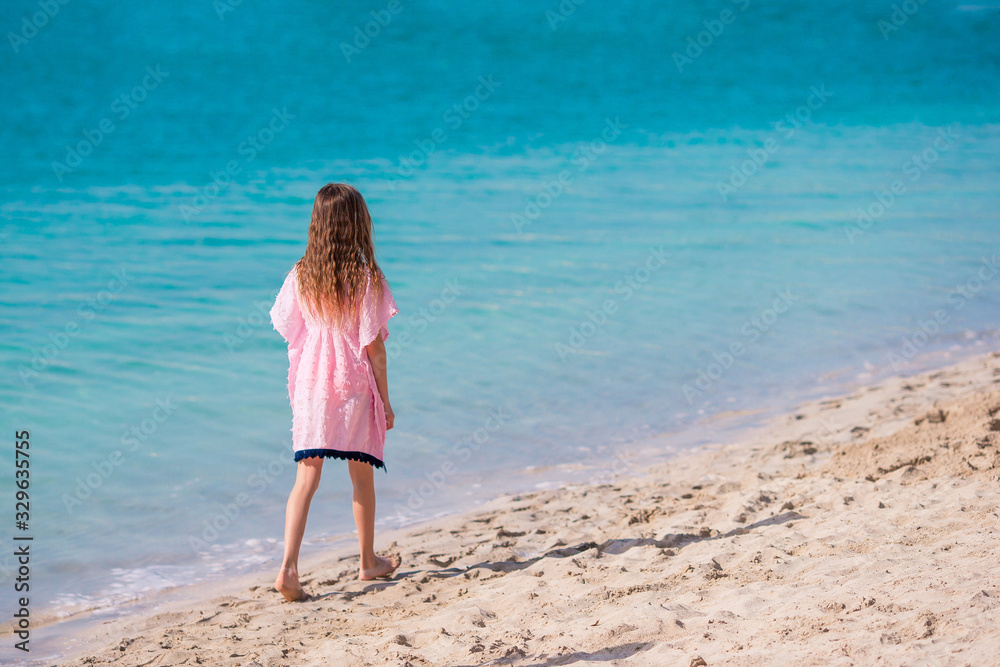 Adorable little girl have fun at tropical beach during vacation Adorable little girl have fun at tropical beach during vacation