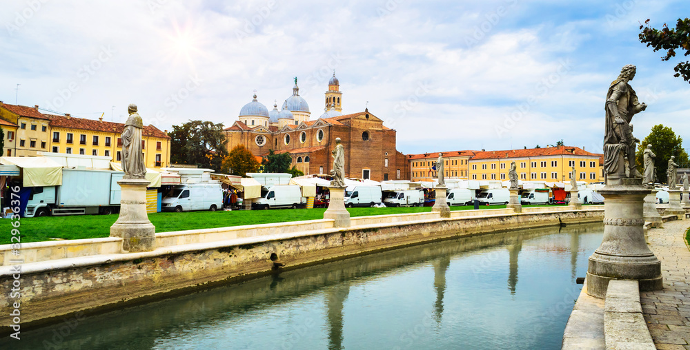 Canal with statues on square Prato della Valle and Basilica di Sant'Antonio in Padova (Padua), Veneto, Italy