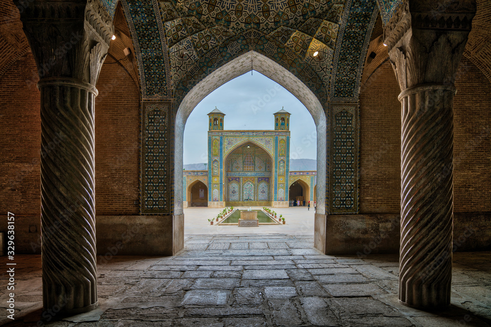 Tourists in courtyard of Vakil Mosque as seen from the hall of prayer, Shiraz, Iran