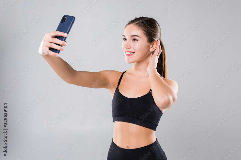 Sporty woman making selfie on smartphone isolated on a white background. Sporty woman making selfie on smartphone isolated on a white background.
