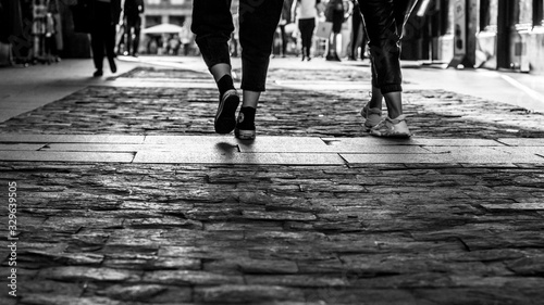 pies de chicas caminando por la calle en blanco y negro