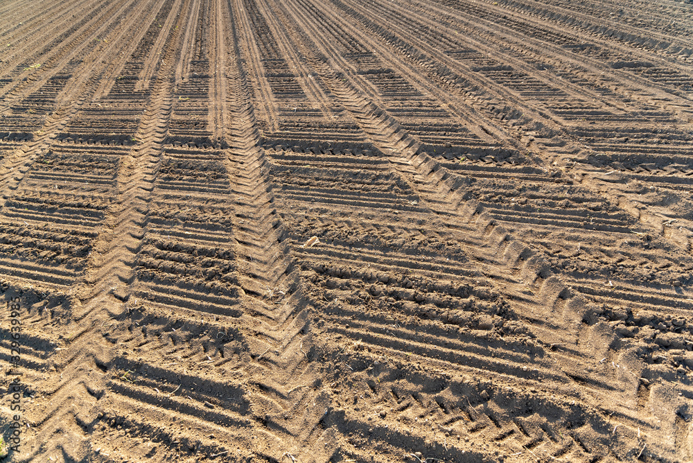 Plowed field brown soil tractor tracks Plowed field brown soil tractor tracks