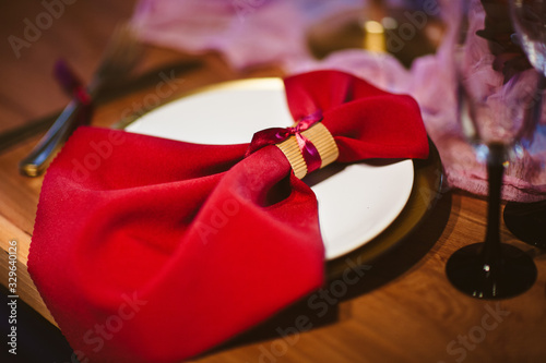 Red napkin lays in the white dish on the wedding table