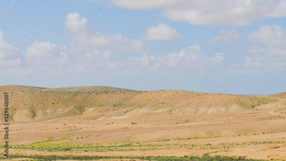 Camera rotated over the hills in desert under the blue sky with white clouds Camera rotated over the hills in desert under the blue sky with white clouds